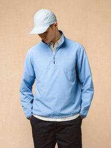 A model wearing a nylon ripstop windbreaker in bright blue.