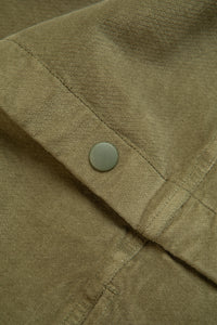 A close-up of the Japanese press snap to the front of a jacket from KESTIN