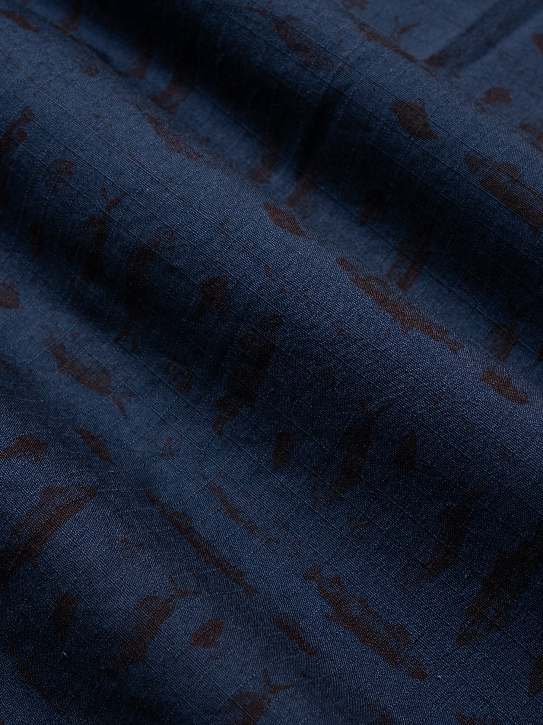 A cotton ripstop fabric in dark blue with printed fish graphics.