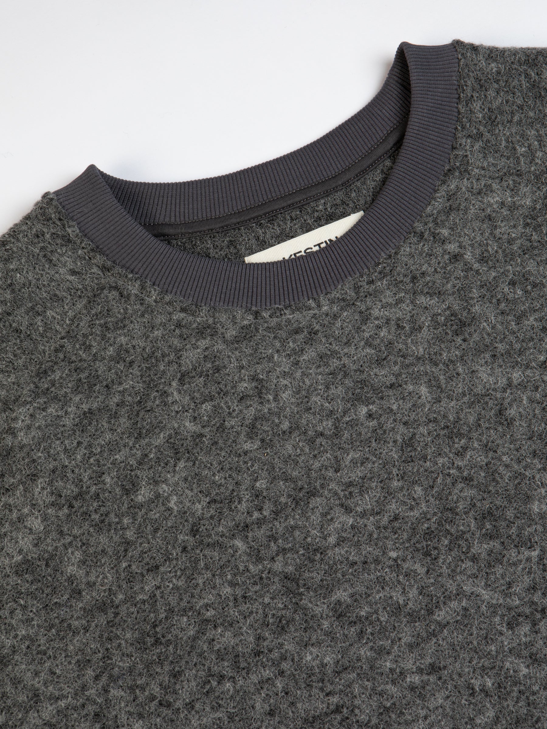 The ribbed crew neck of the KESTIN Junction Sweat, made from grey wool.