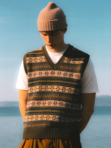 A model wearing a t-shirt, sweater vest and beanie from menswear brand KESTIN.