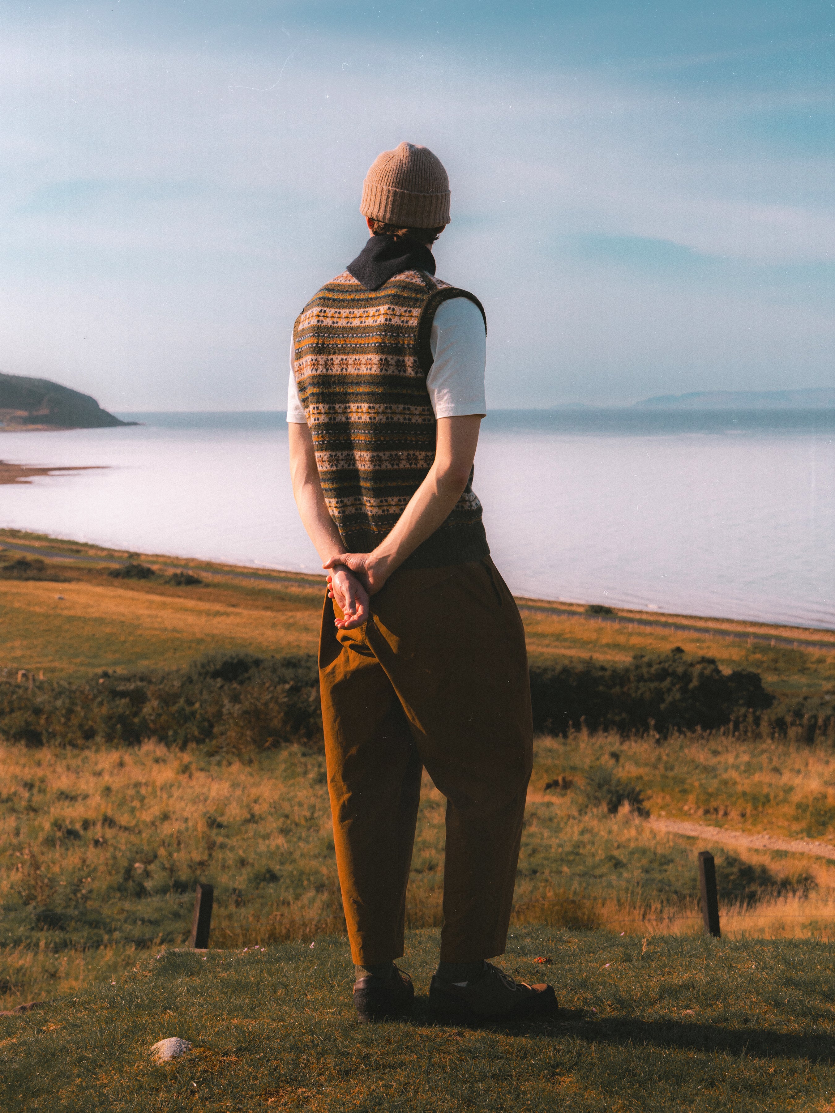 A model fabing the sea from the Isle of Arran, wearing clothing from KESTIN.