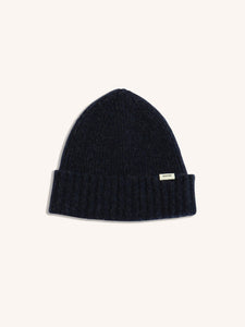 A navy blue beanie made from lambswool, on a white background