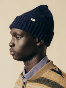 A man wearing a navy blue beanie from menswear brand KESTIN