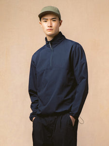 A man wearing a navy zip neck jacket from Scottish menswear designer KESTIN.