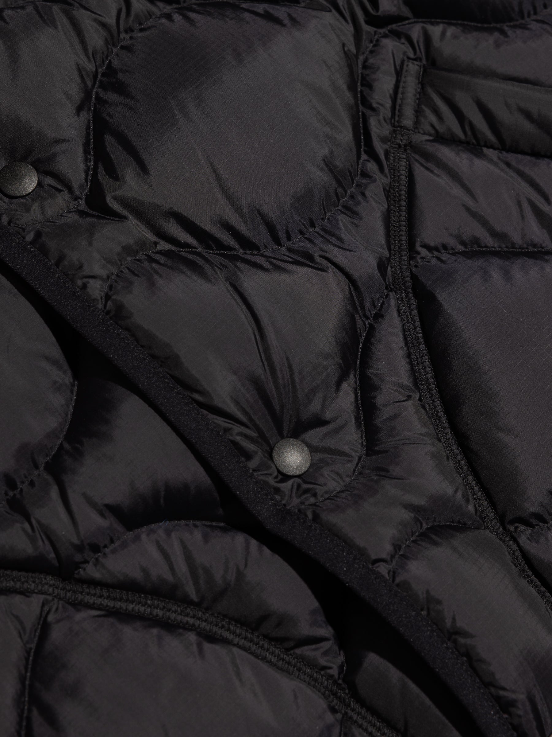 The Japanese press snap to the front of the KESTIN Cuillin Down Vest in black.