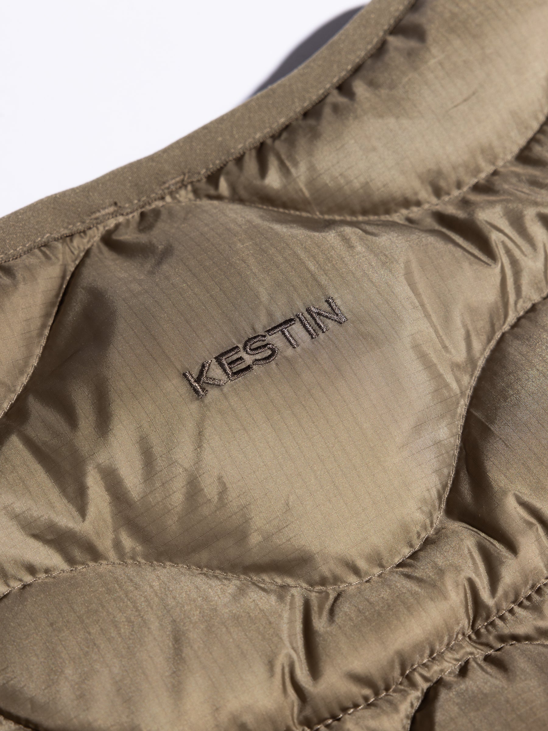 An embroidered KESTIN logo to the back of the Cuillin Down Vest in olive green.