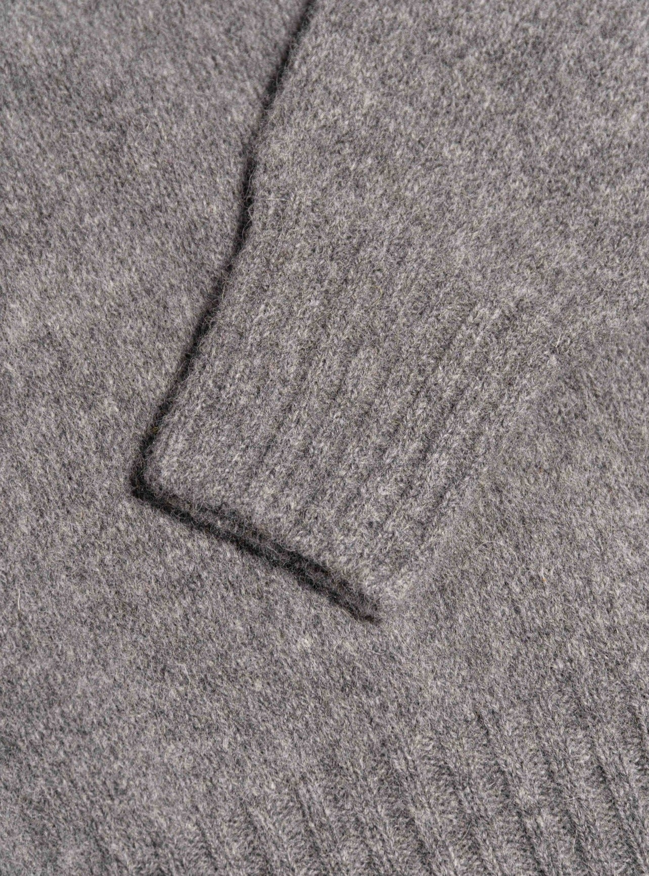 A close-up of the cuff of the Shetland Crew Neck in grey, by KESTIN.