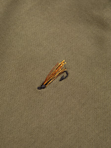 An embroidered fishing fly to the chest of an olive green sweatshirt.