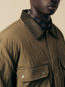 A green jacket made from Italian nylon with a corduroy collar.