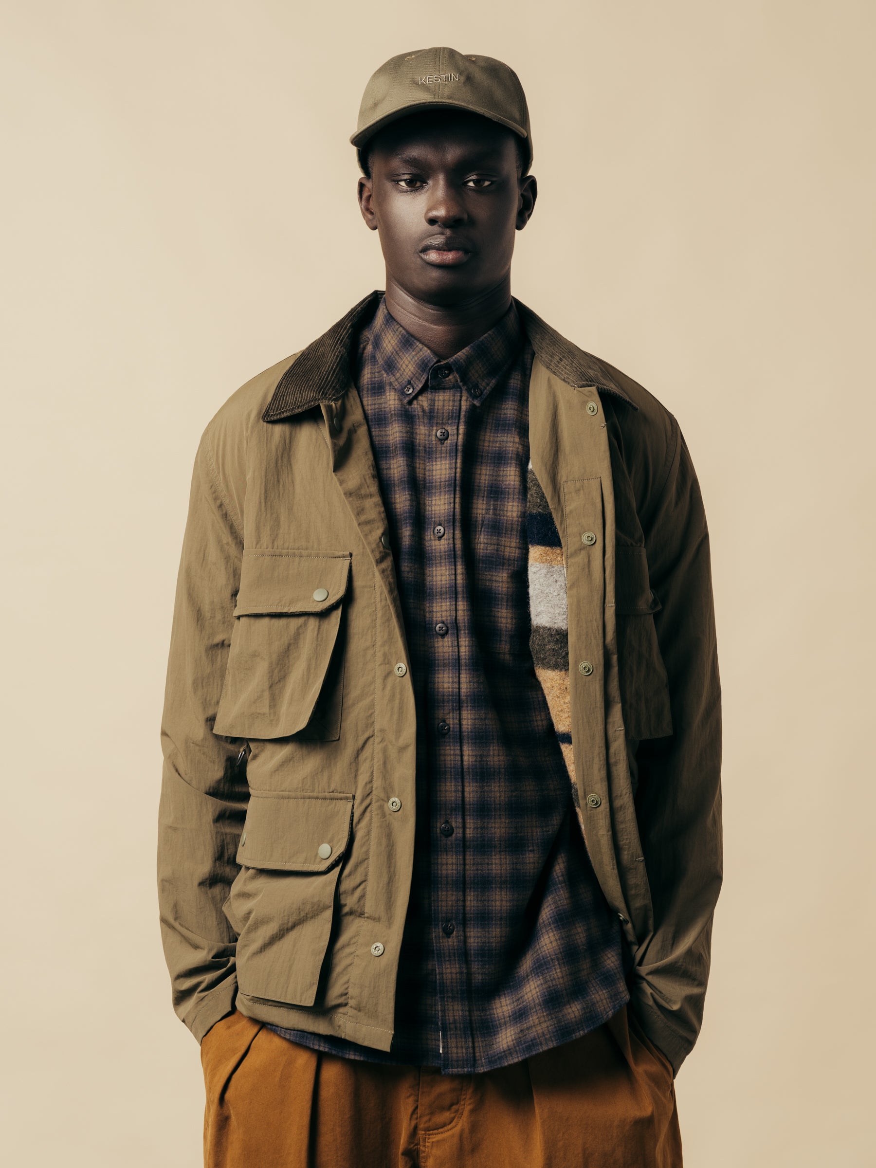 A model wearing a check shirt and a country-style jacket from menswear brand KESTIN.