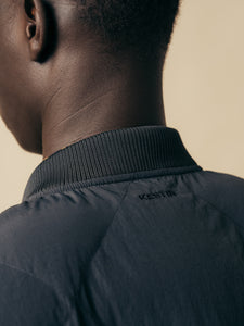 The ribbed collar and logo embroidery of the KESTIN Linton Vest in Charcoal.