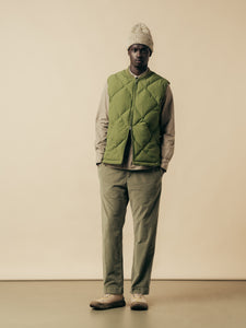 A man wearing a technical overshirt, insulated vest and moleskin trousers.