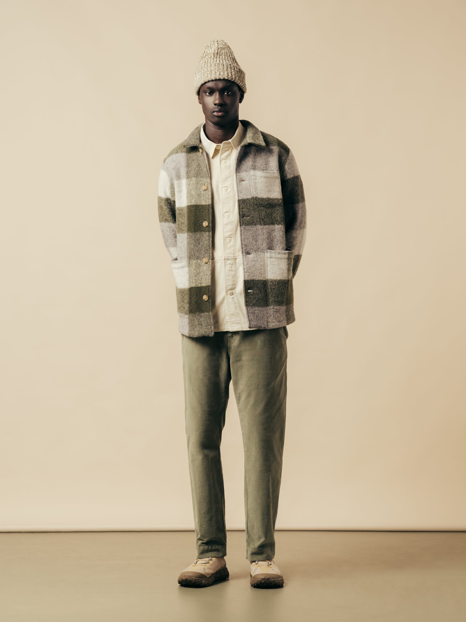 A model wearing a green layered autumn/winter outfit from menswear brand KESTIN.