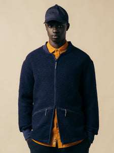 A model wearing a navy blue fleece and a yellow shirt from designer brand KESTIN.