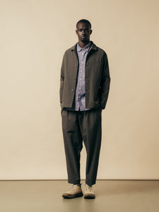 A man wearing a slate grey suit and a blue shirt from menswear designer KESTIN.