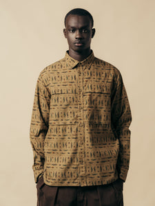 A model wearing a green overshirt with a graphic print.