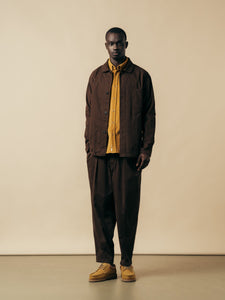 A man wearing a dark brown and yellow outfit from Scottish menswear designer KESTIN.