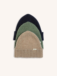 Three different coloured beanies, stacked on a white background