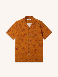 An orange short sleeve shirt with a floral print, on a white background.