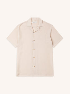 A plain cream-coloured short sleeve shirt, on a white background.