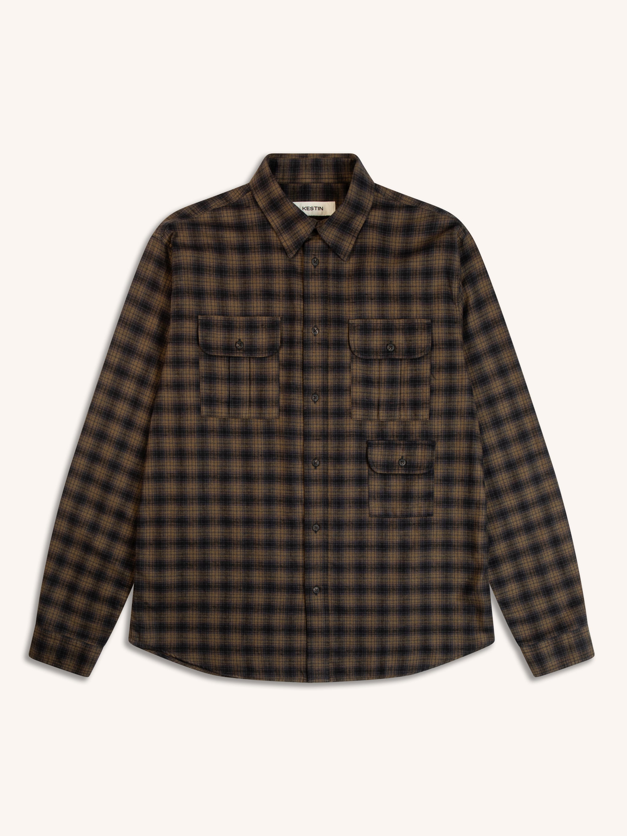 A check flannel shirt with three buttoned pockets, on a white background.