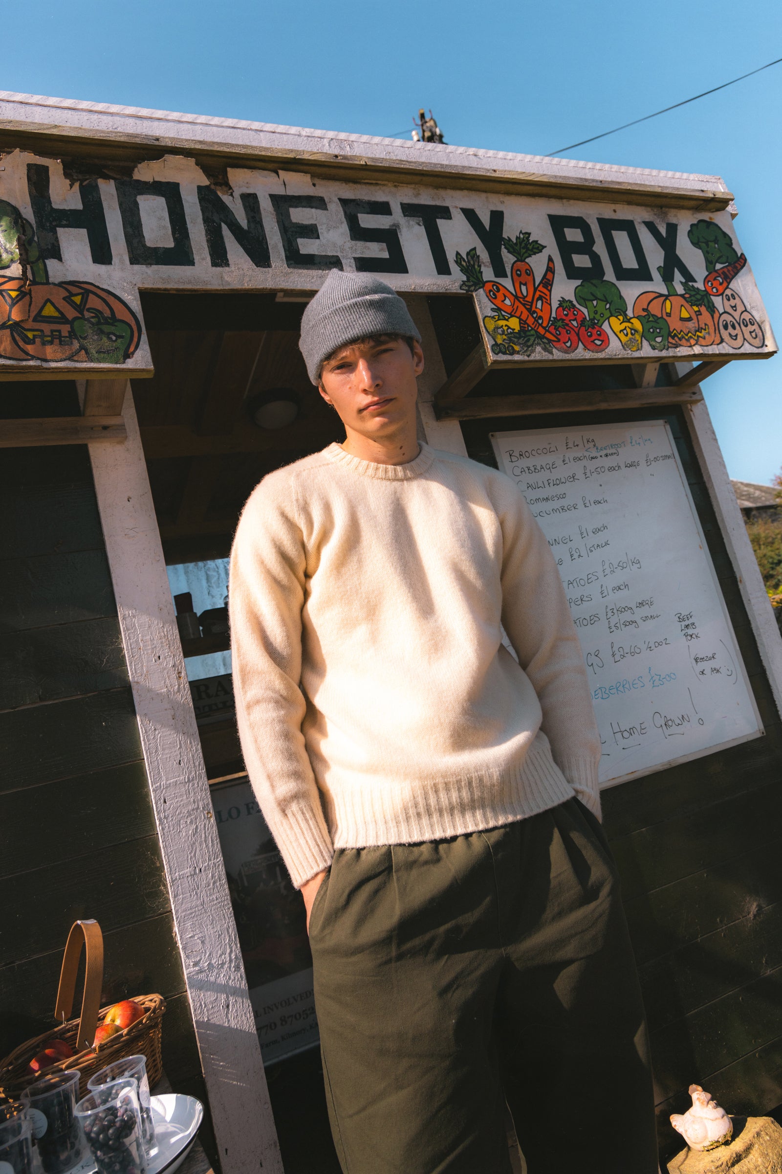 A model stood by an honesty box on the Isle of Arran, wearing a knitted sweater.