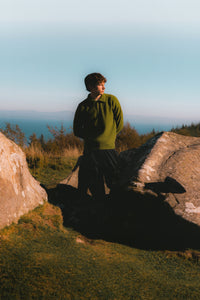 A man standing on the Isle of Arran, wearing made in Scotland knitwear.