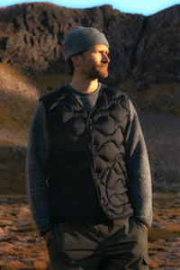 A man wearing a wool sweatshirt and a down vest from menswear brand KESTIN.