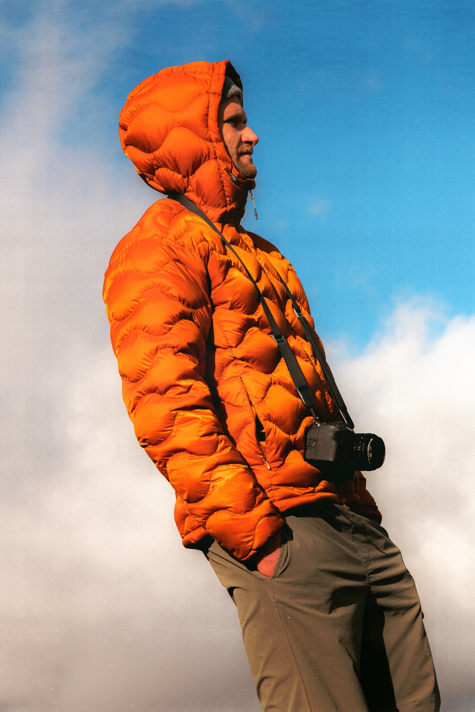 A man wearing a down insulated jacket, stood with his camera in Scotland