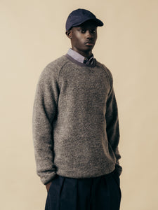 A model wearing a grey wool sweatshirt, a shirt and a cap from KESTIN.