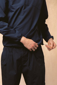 A man adjusting the hem of the KESTIN Aberfeldy Windbreaker.