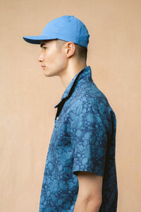 The side profile of a model wearing a shirt and cap from menswear designer KESTIN.