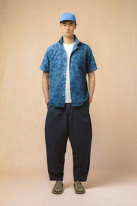 A model wearing a blue short sleeve shirt and relaxed fit pants from designer KESTIN.