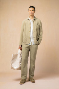 A model wearing a white shirt and a casual khaki suit.