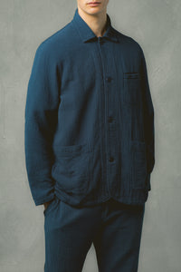 A model wearing a navy blue chore coat in a casual textured navy blue fabric.