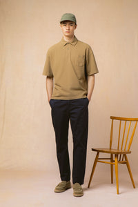 A model wearing slim fit chinos and a polo shirt from menswear designer KESTIN.