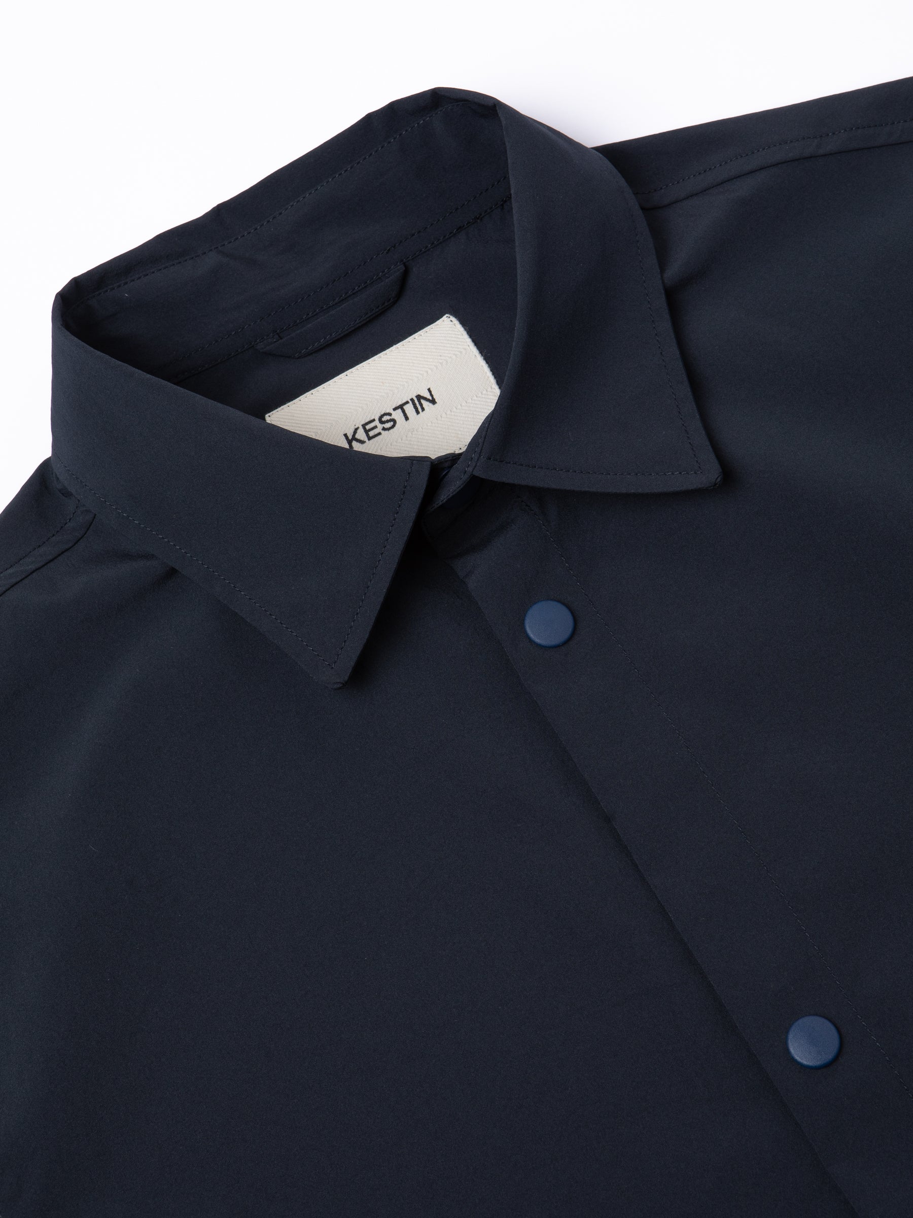 A navy blue coach jacket made from a temperature regulating fabric.