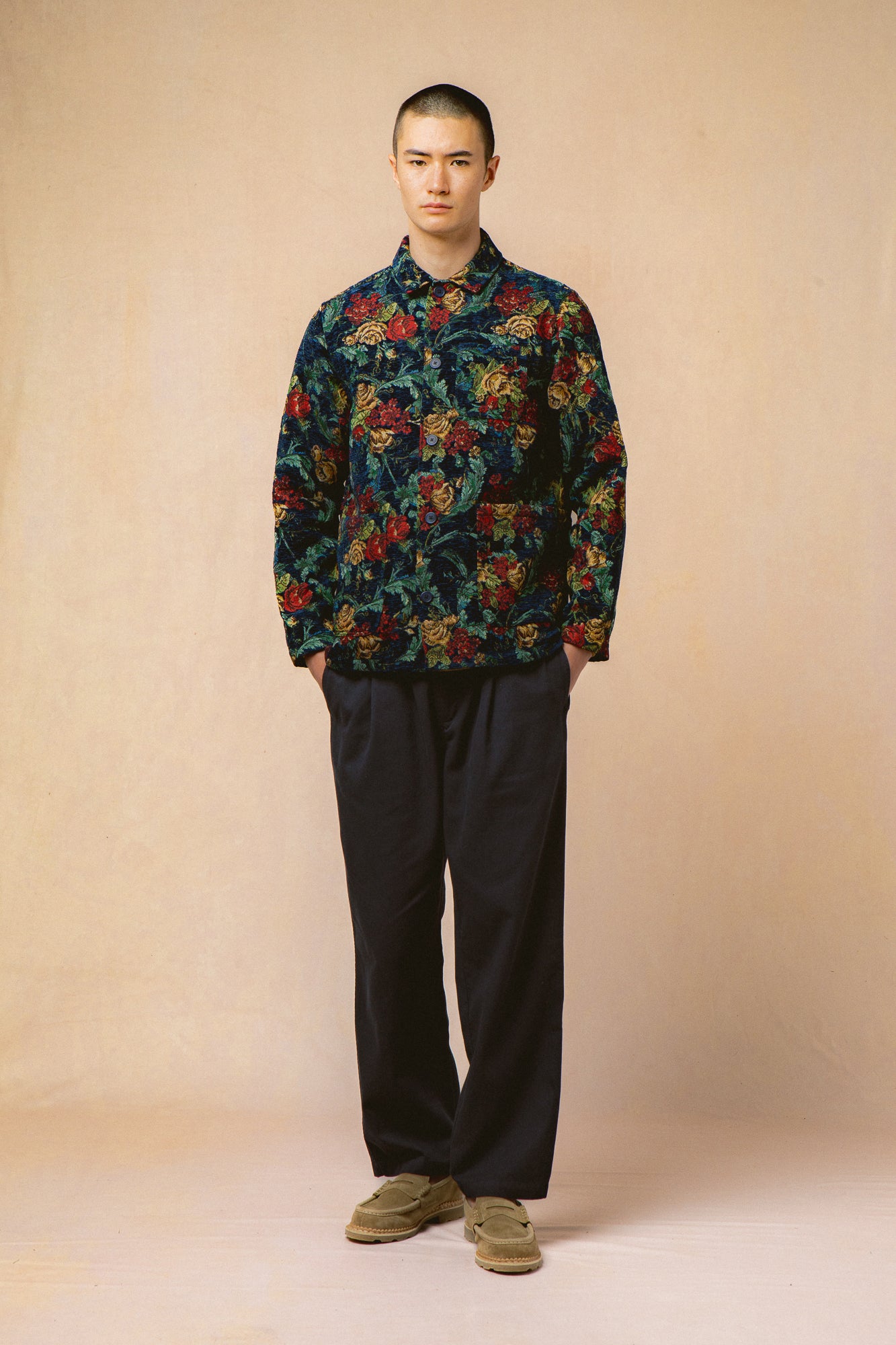 A model wearing navy trousers and floral jacket from Scottish fashion brand KESTIN.