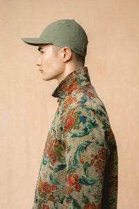 A model wearing a floral jacket and cap from Scottish clothing designer KESTIN.