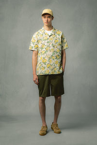 A man wearing a floral shirt and olive green shorts from menswear brand KESTIN.