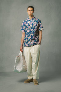 A model wearing a short sleeve shirt and cream trousers from KESTIN.