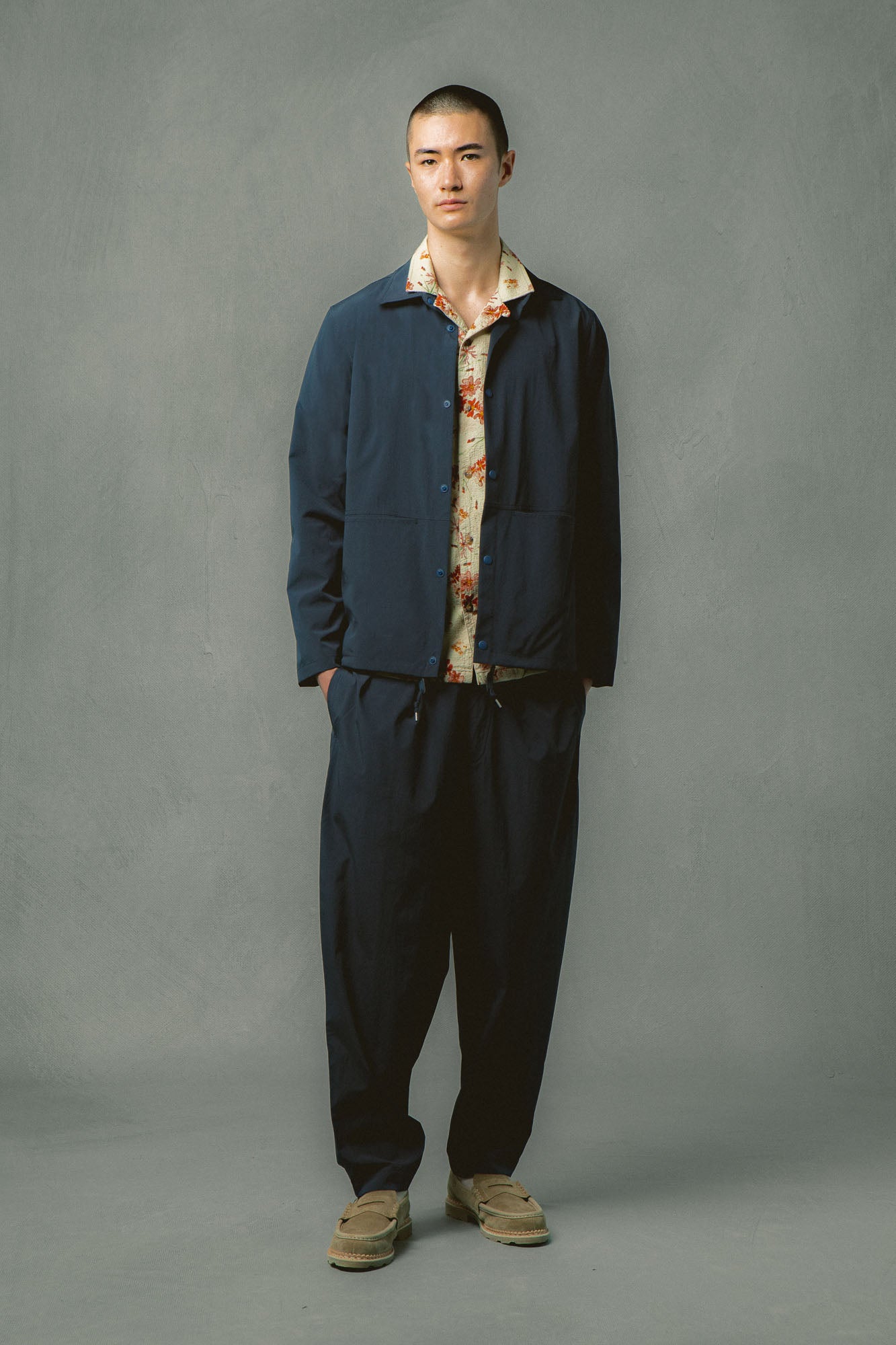 A model wearing trousers and a jacket from KESTIN, made in a temperature regulating fabric.