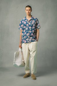 A model wearing white trousers and a floral shirt from menswear designer KESTIN.