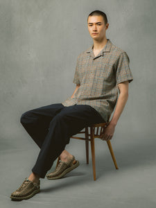 A model sitting down, wearing a spring outfit from Scottish designer KESTIN.