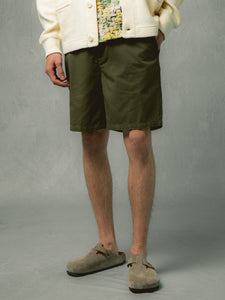 A model wearing olive green shorts with a cardigan and Birkenstock Bostons.