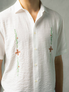 A men's white linen shirt with embroidered celtic artwork to the front.