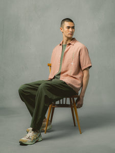 A model wearing green trousers and a pink shirt from Scottish menswear brand KESTIN.