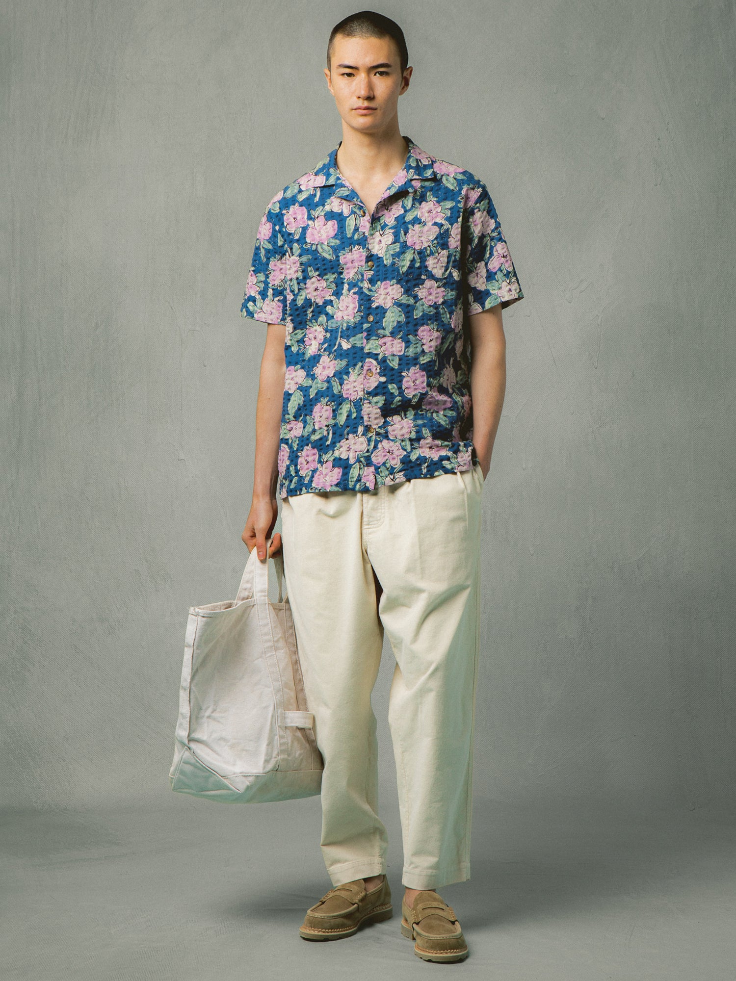 A model wearing a blue floral shirt and white corduroy pants from menswear brand KESTIN.