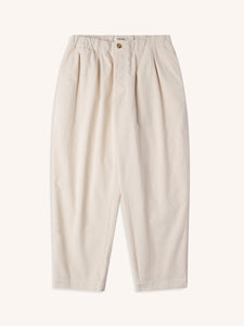 A pair of cream coloured corduroy trousers in a relaxed fit, on a white background.